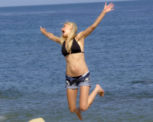 Jumping Blonde in Bikini Top and Shorts