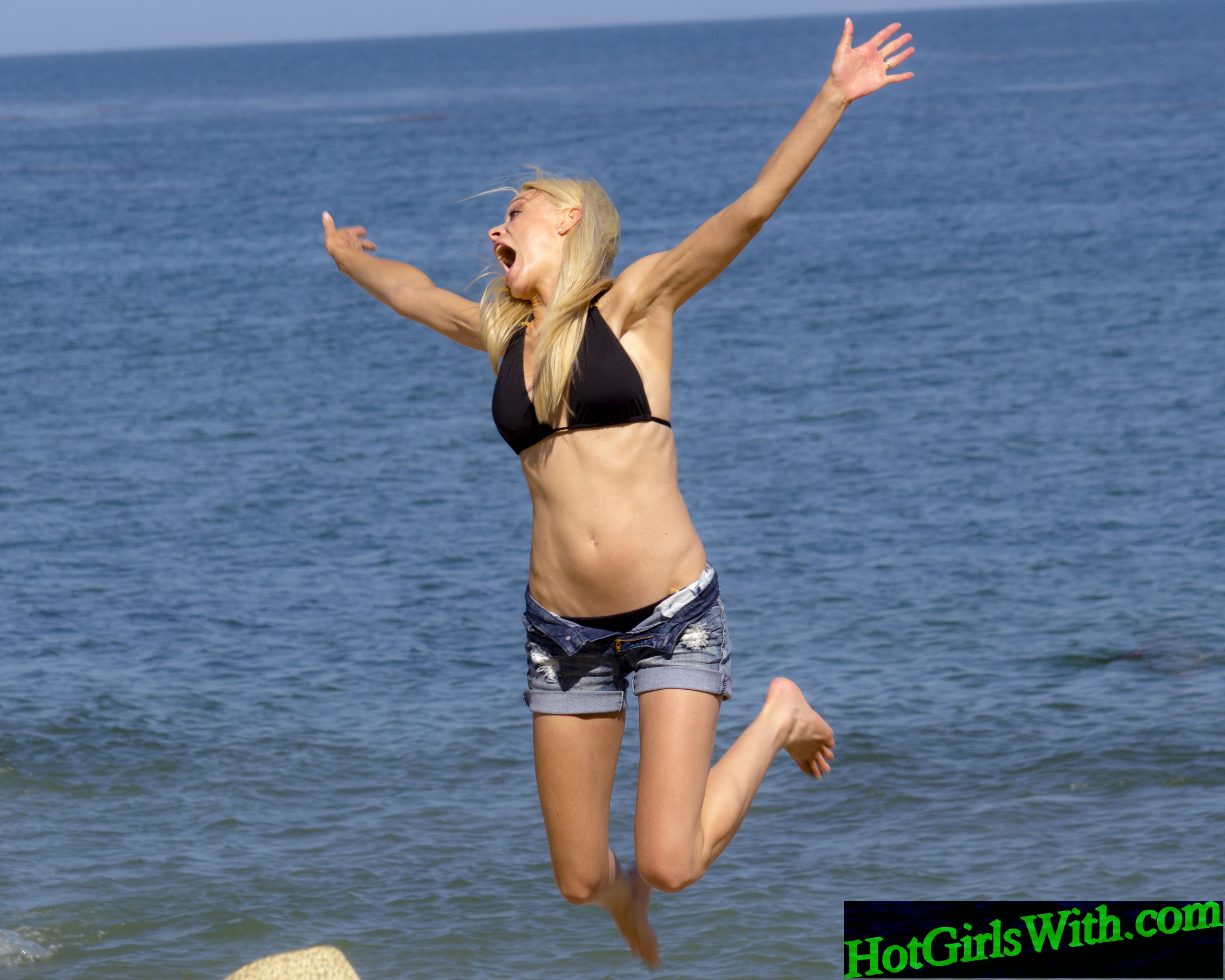 Jumping Blonde in Bikini Top and Shorts